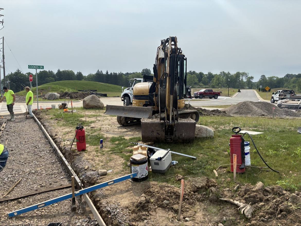 Yellow excavator at a residential street job site