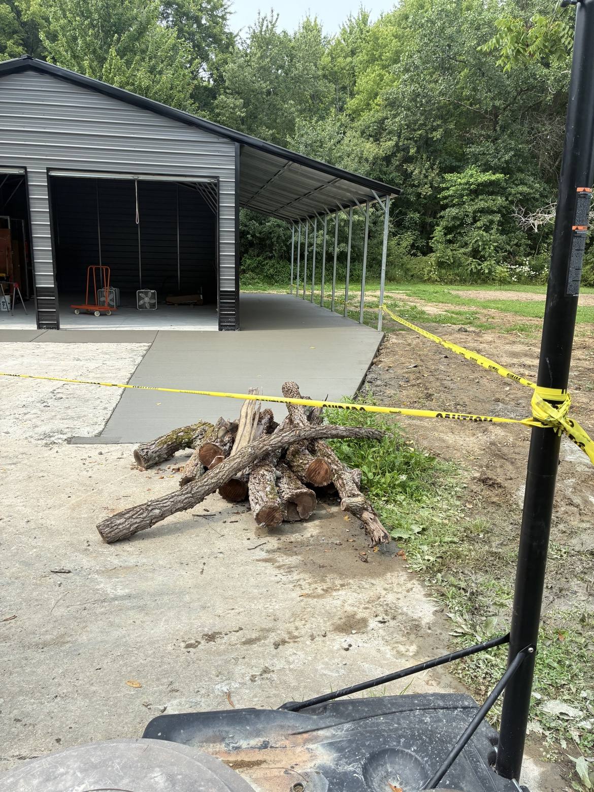 Fresh concrete pad poured beside a metal building
