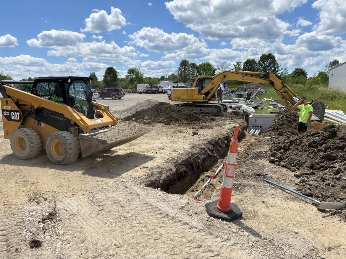 CAT skid steer and excavator doing trench site work