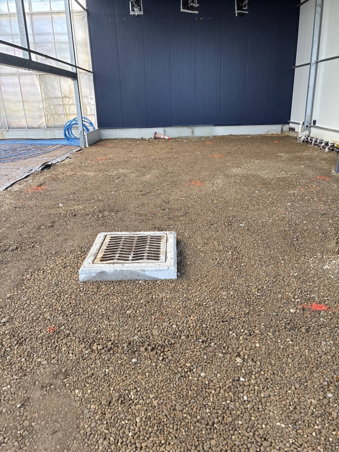 Concrete drainage catch basin set in gravel